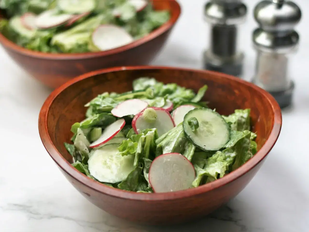 Frischer Salat mit Gurken und Radieschen, angemacht mit einem cremigen french dressing.