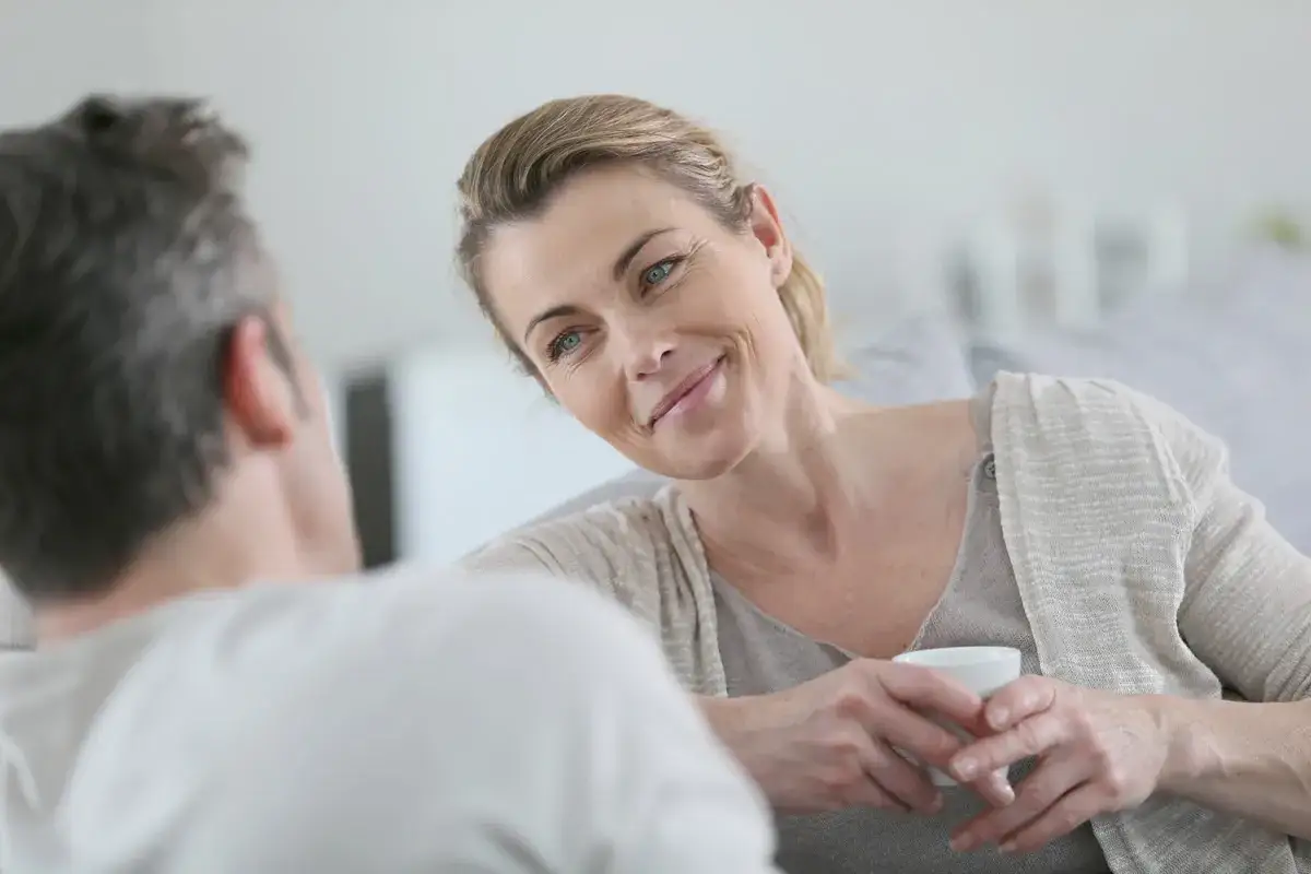 Donna sorride a un uomo, un dialogo intimo che potrebbe riguardare una coppia aperta, parere psicologo.