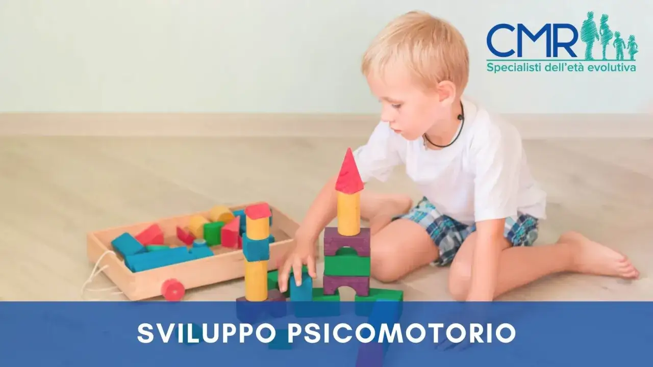 Bambino gioca con blocchi colorati, promuovendo lo sviluppo psicomotorio e del linguaggio.