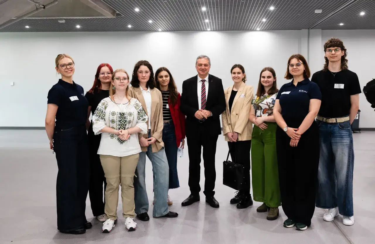 Grupa studentów i wykładowca na wydarzeniu związanym z lingwistyką stosowaną w Warszawie.