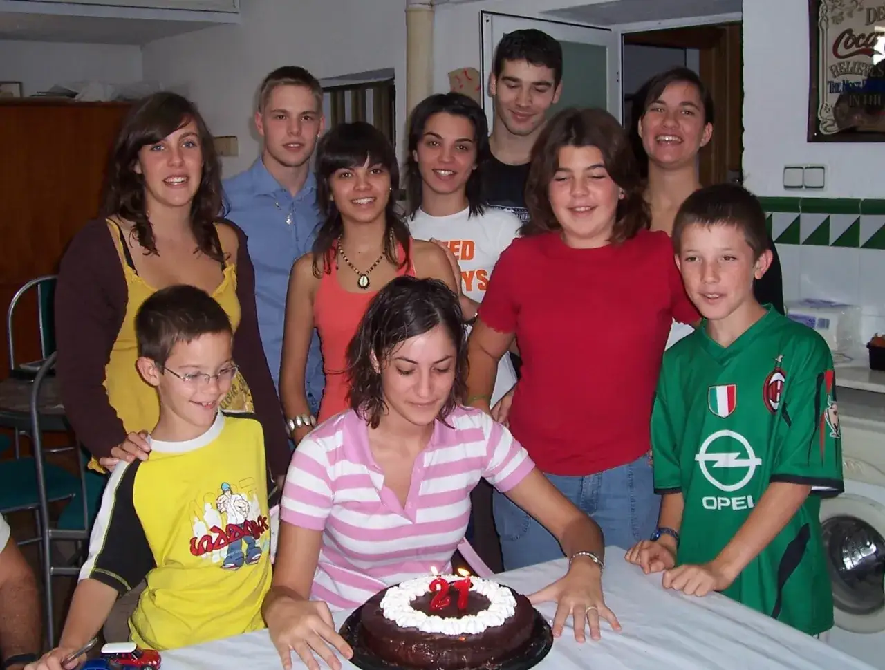Gruppe feiert Geburtstag mit Kuchen. Ein Junge im Fu&szlig;balltrikot, ein M&auml;dchen mit Kerzen auf dem Kuchen. Ein sch&ouml;ner Moment des spanisch austausch.