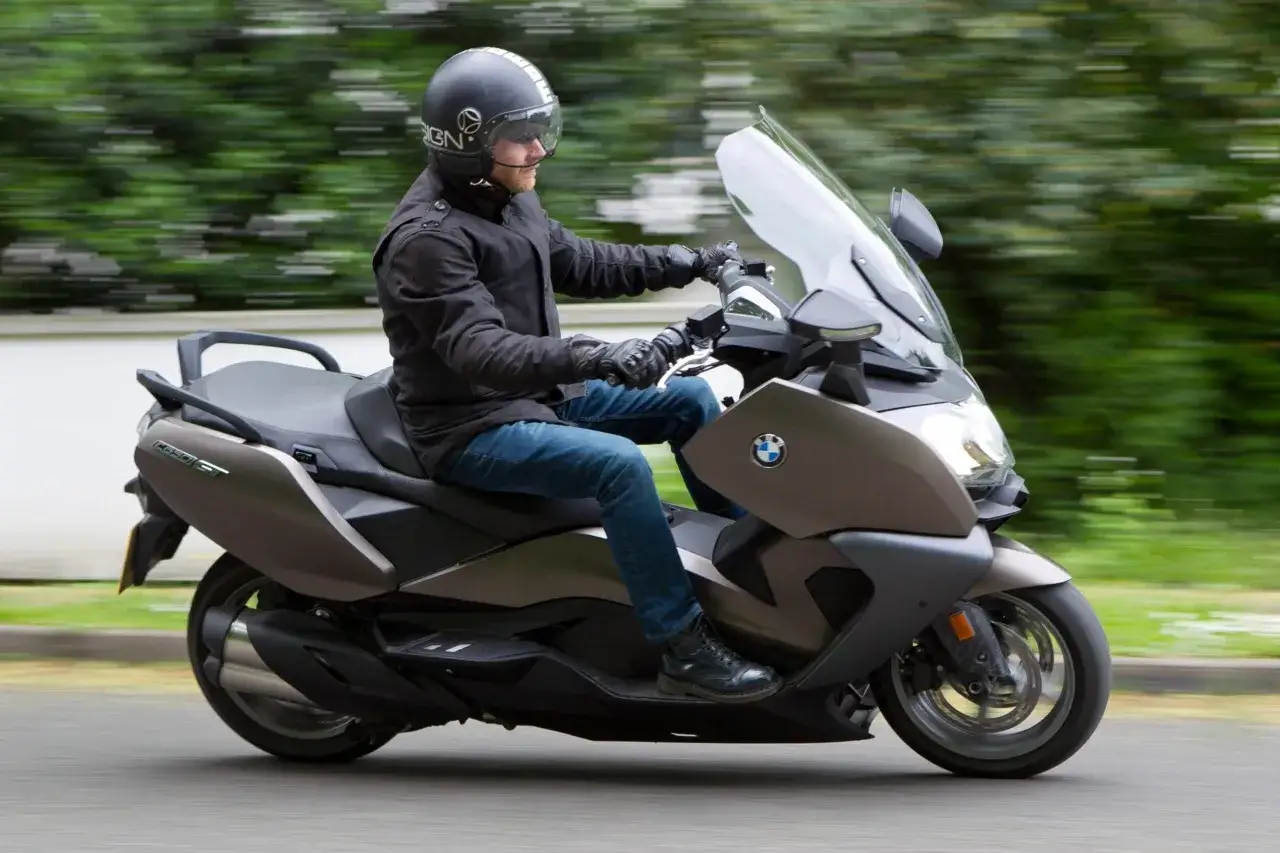 Mężczyzna w kasku i kurtce jedzie na skuterze BMW C650 GT. Poznaj jego dane techniczne i możliwości.