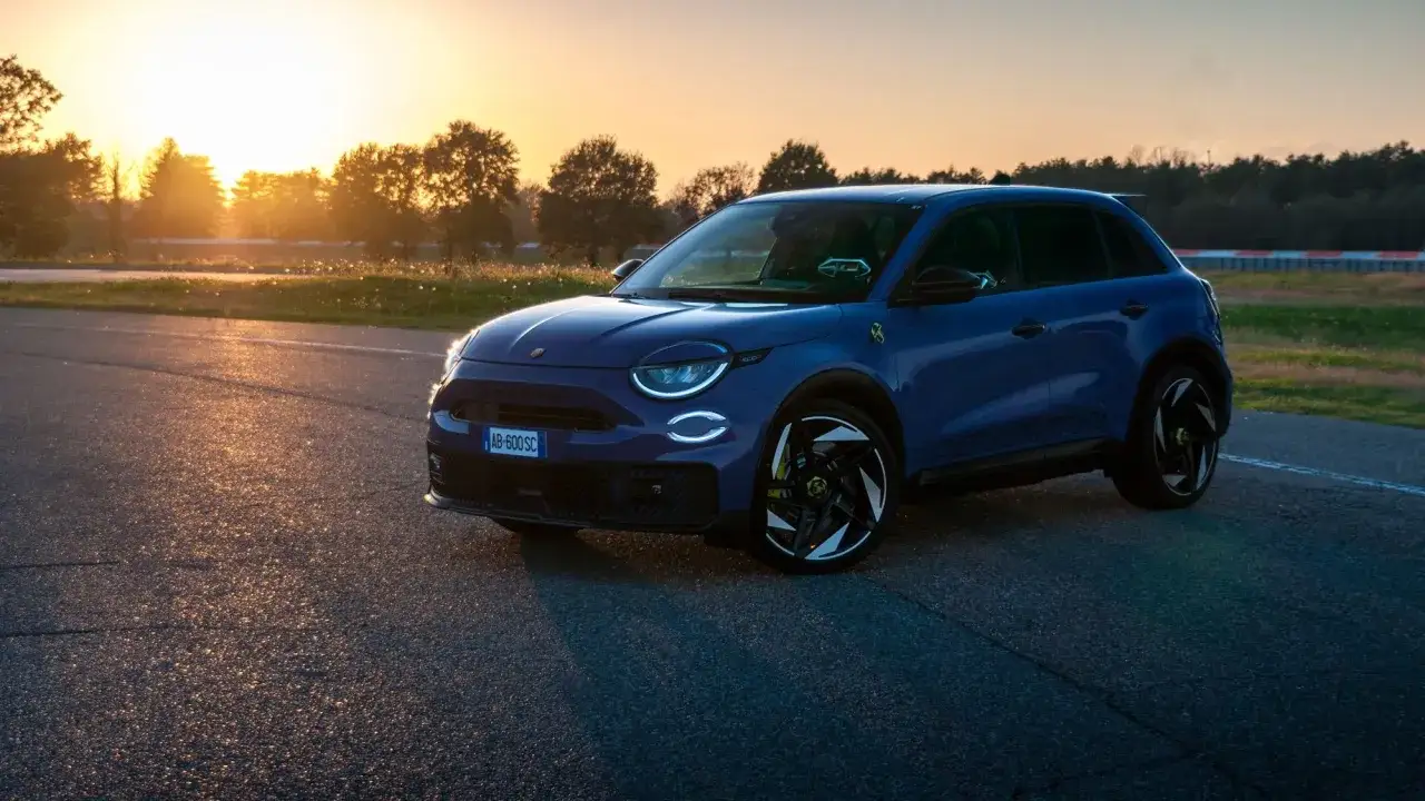 Niebieski Abarth 600e na torze podczas zachodu słońca. Testy nowego modelu w pełnym słońcu.