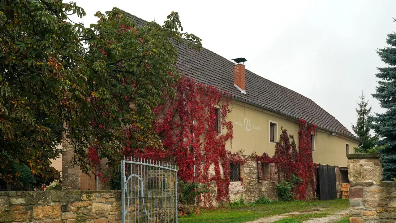 Herbstliche Weinreben ranken sich um das Geb&auml;ude des Antaios Verlags.