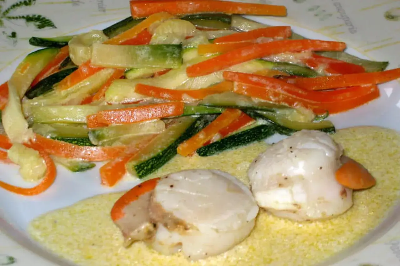 Délicieux nage de st jacques aux légumes croquants, carottes et courgettes coupées en julienne, nappées d'une sauce crémeuse.