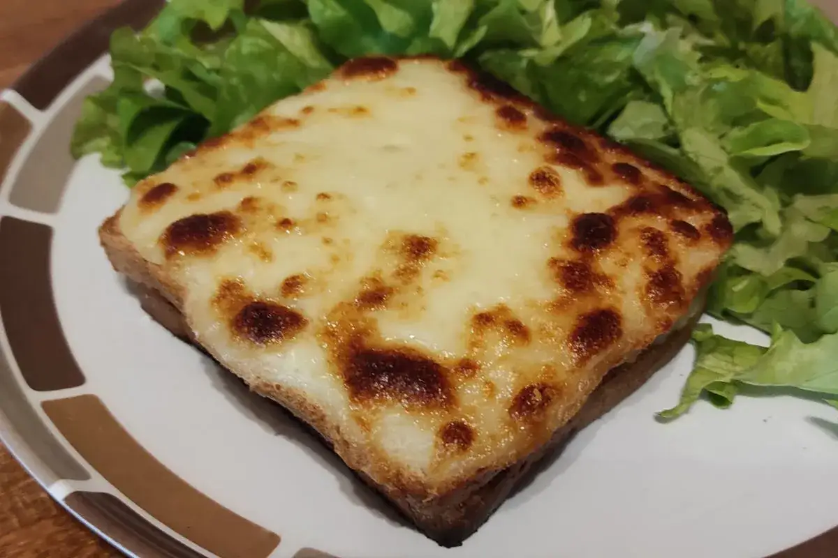 Un délicieux croque monsieur bistrot, gratiné à la perfection, servi avec une salade verte croquante.