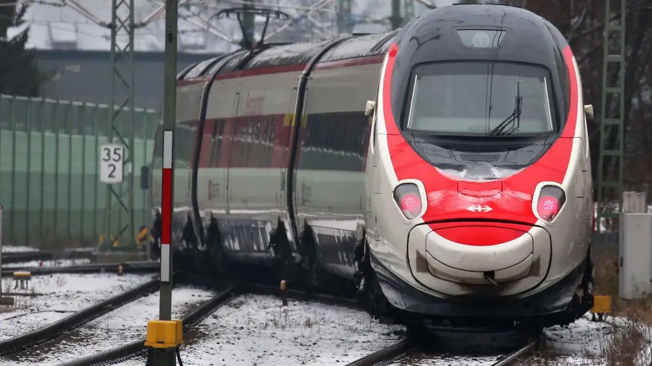 Ein roter und weißer ece train fährt durch eine verschneite Landschaft.