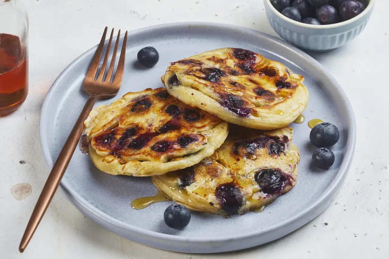 Leckere Blaubeerpfannkuchen mit frischen Beeren und Sirup. Ein einfaches Blaubeerpfannkuchen Rezept für den perfekten Brunch.