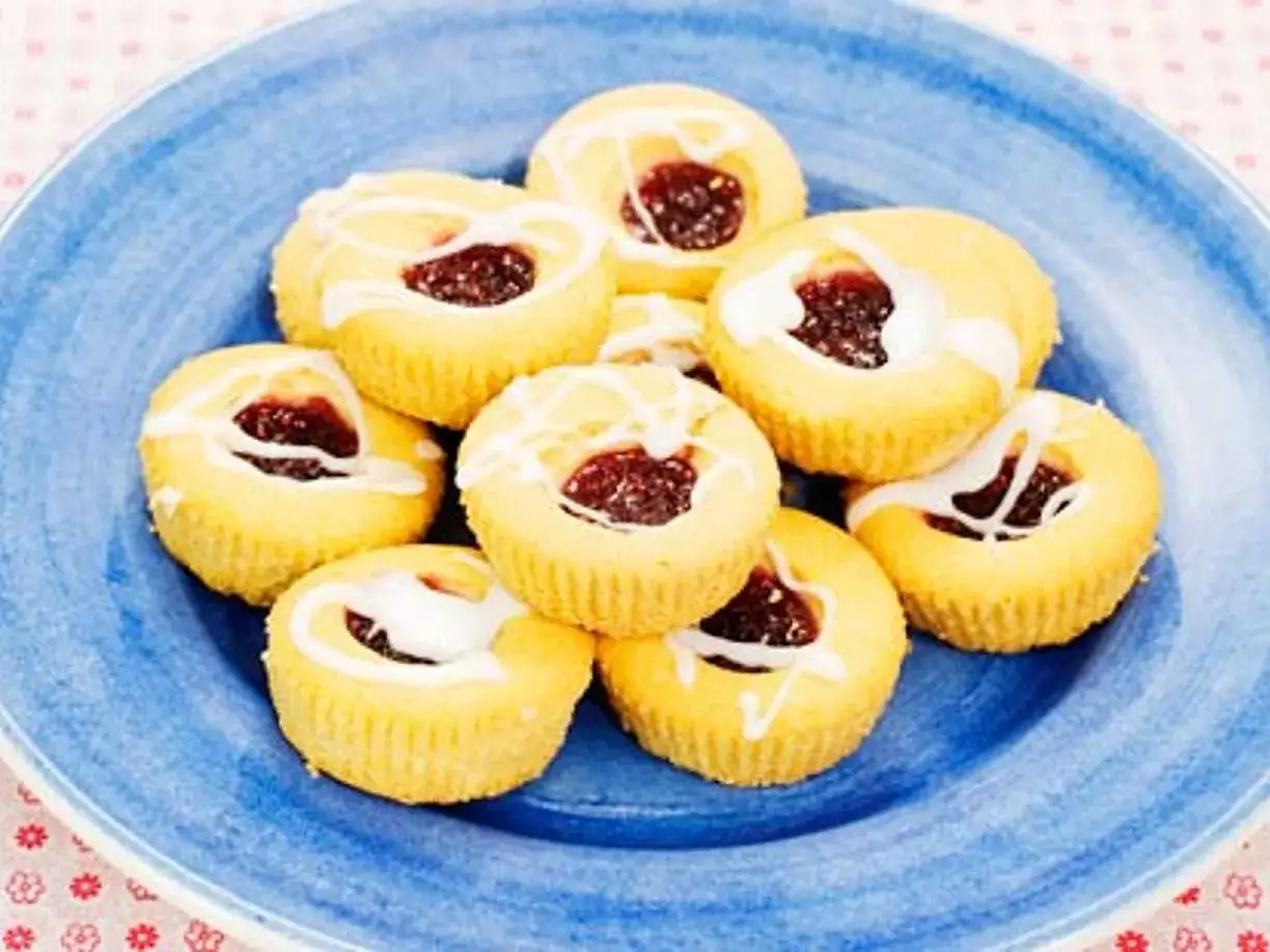 Hallongrottor recept: sm&aring;, runda kakor med hallonsylt i mitten, dekorerade med glasyr. Perfekta till fikat!