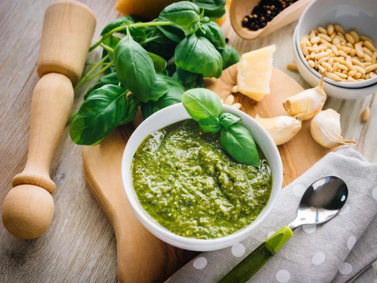 Un profumato pesto alla genovese, con basilico fresco, pinoli, aglio, parmigiano e pepe. Ingredienti pronti per un piatto delizioso.