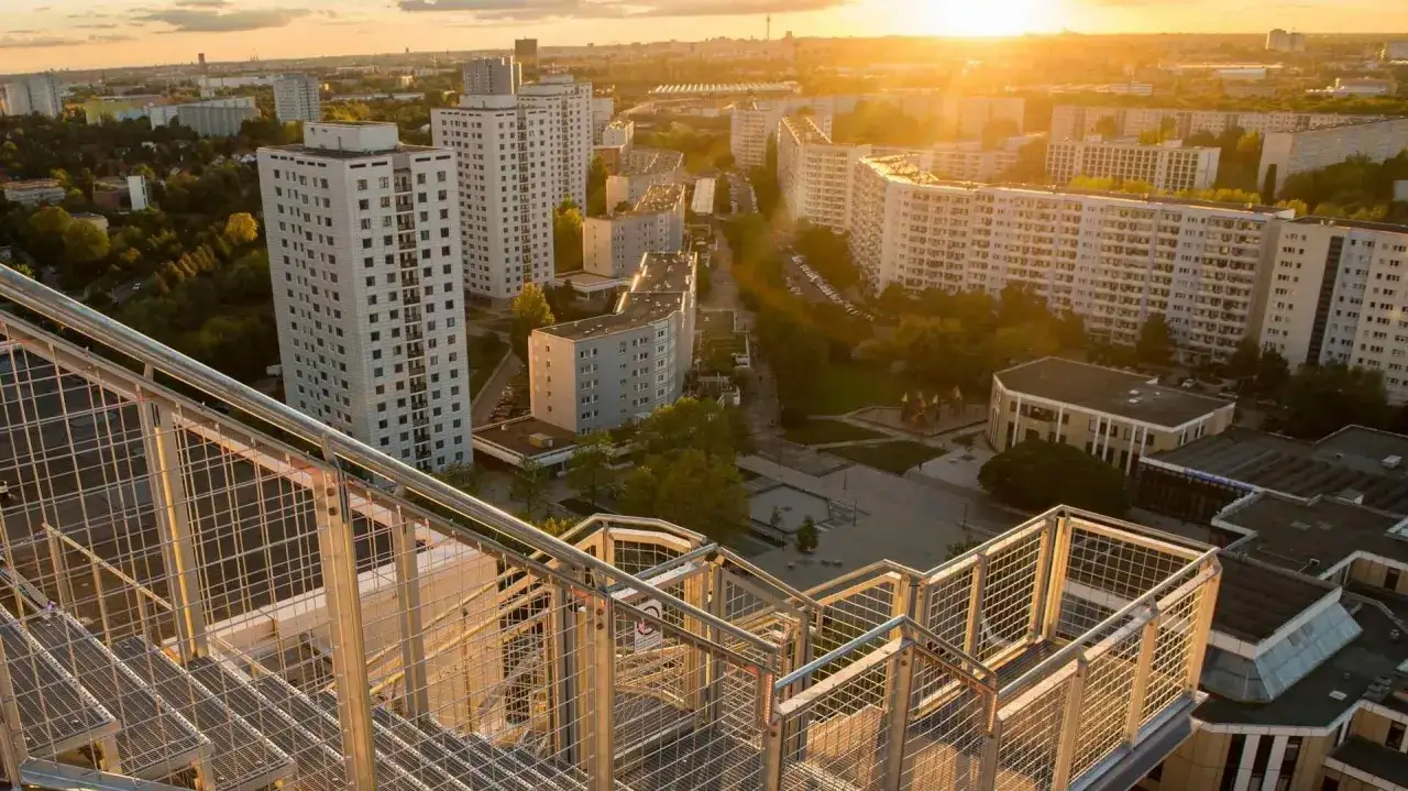 Blick von der Treppe des Skywalk Marzahn auf die Wohnbl&ouml;cke und die untergehende Sonne.