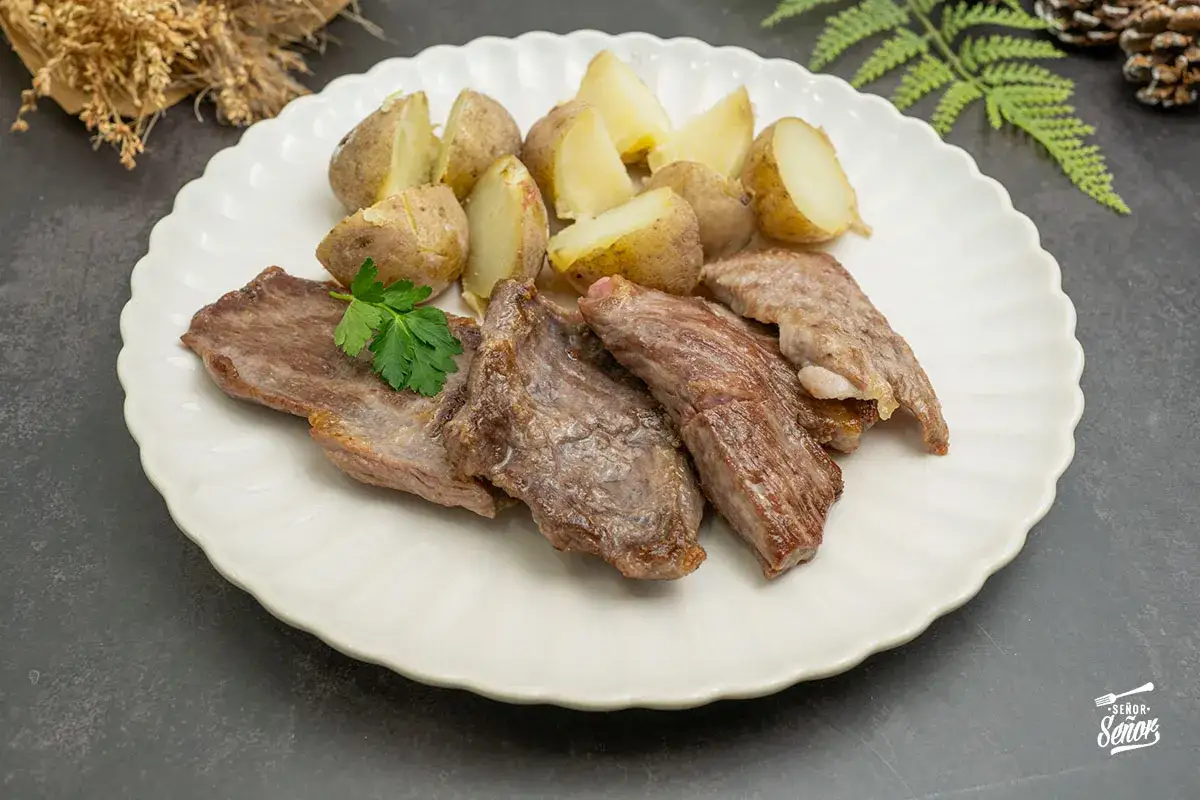 El secreto ib&eacute;rico, jugoso y tierno, acompa&ntilde;ado de patatas asadas y perejil fresco. Un manjar para descubrir.