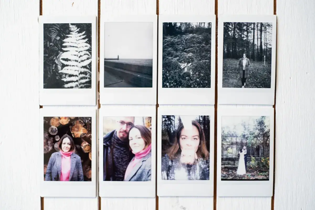 Osiem zdjęć Instax: paproć, schody nad wodą, kobieta w lesie, kobieta w płaszczu, stos drewna, para, kobieta, para młoda.