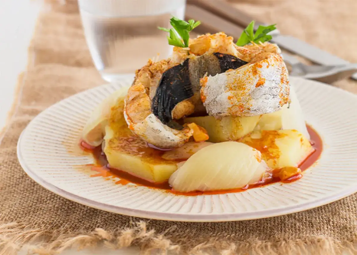 Deliciosa merluza a la gallega servida con patatas y cebolla, bañada en una sabrosa salsa.