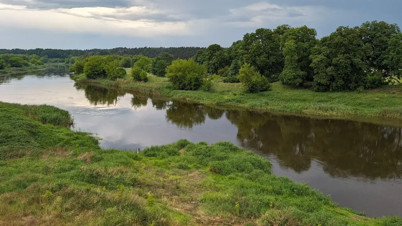 Malowniczy krajobraz nad rzeką, idealne miejsce na odkrywanie międzychód atrakcje. Zielone brzegi i spokojna woda zapraszają do relaksu.