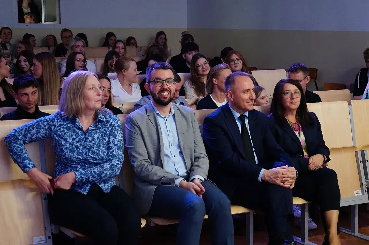 Ludzie siedzą na widowni. To może być wydarzenie związane z edukacją, gdzie omawiane jest, co to jest wykształcenie średnie zawodowe.