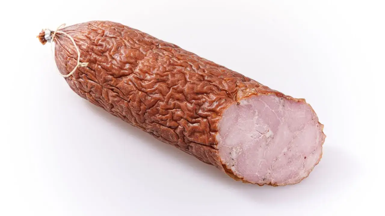 Wędzona kiełbasa, z której jest salami, ma pomarszczoną skórkę i różowy, soczysty środek.