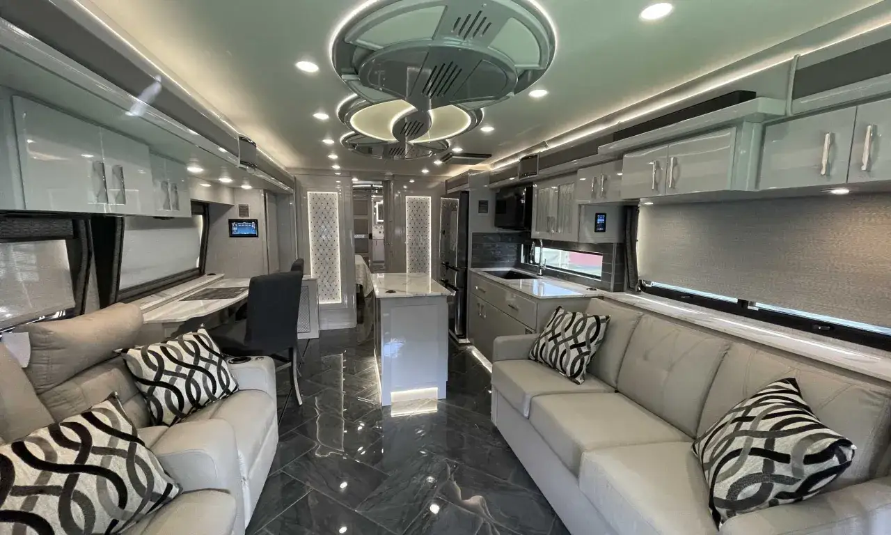 Int&eacute;rieur luxueux d'un camping-car am&eacute;ricain, avec canap&eacute;s confortables, cuisine moderne et &eacute;clairage d'ambiance.