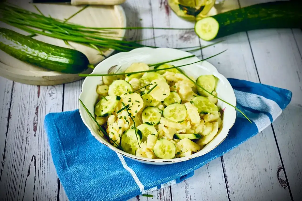 Frischer Kartoffelsalat mit Gurken, garniert mit Schnittlauch. Ein leichter und leckerer Sommersalat.