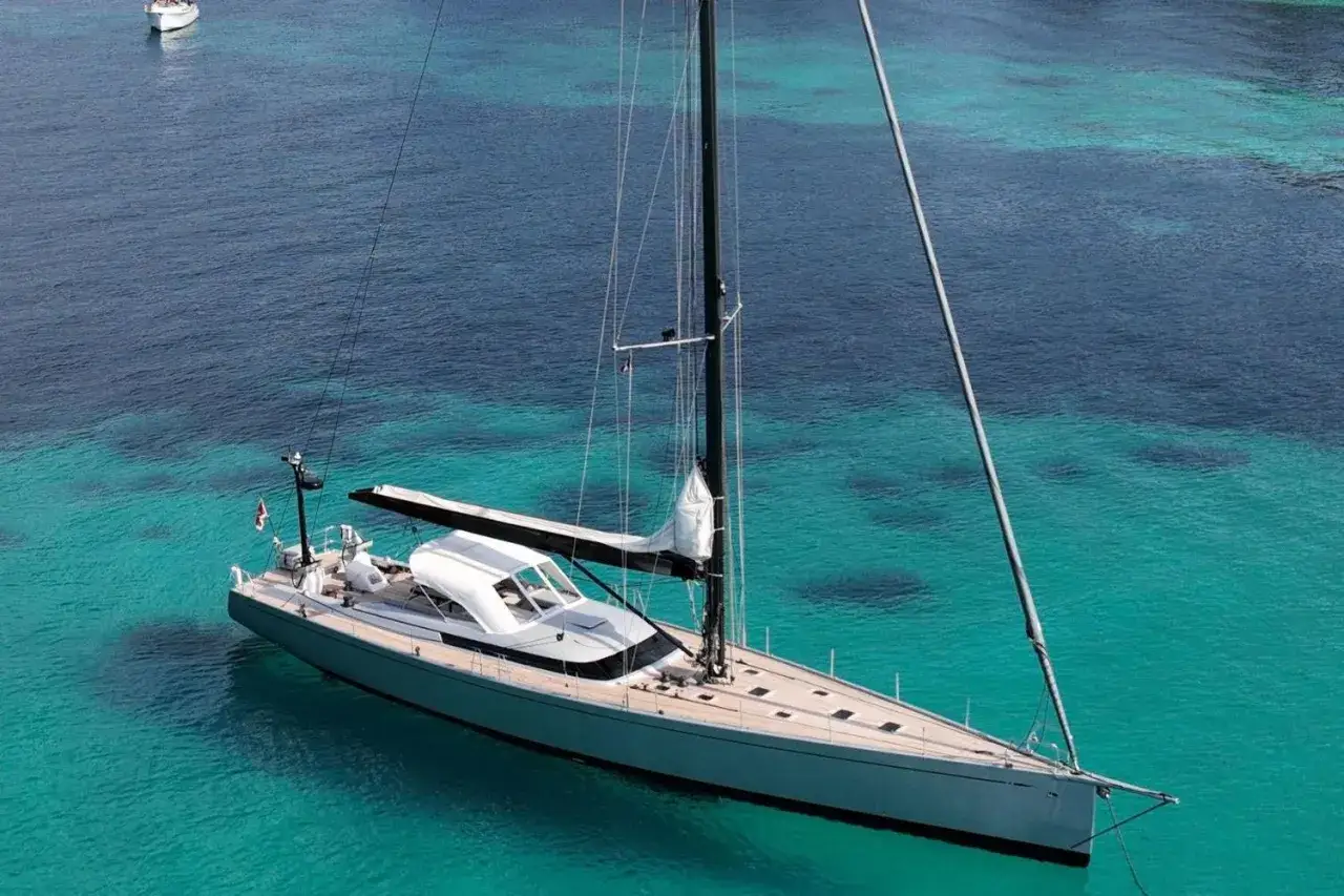 Un magnifique voilier Swan 76 navigue dans des eaux turquoise cristallines.