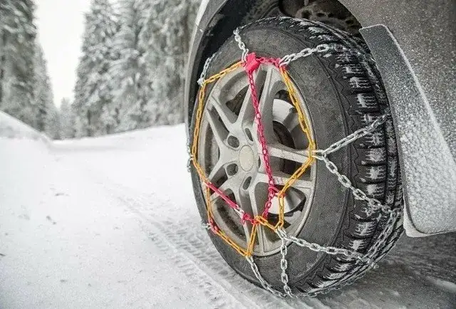 Samoch&oacute;d z łańcuchami śniegowymi na oponach w g&oacute;rach
