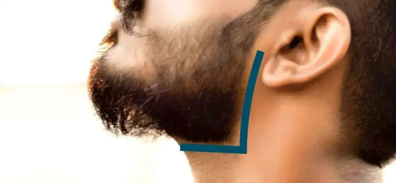 Un homme se fait tailler la barbe. Une ligne bleue indique la forme de la joue et du cou.
