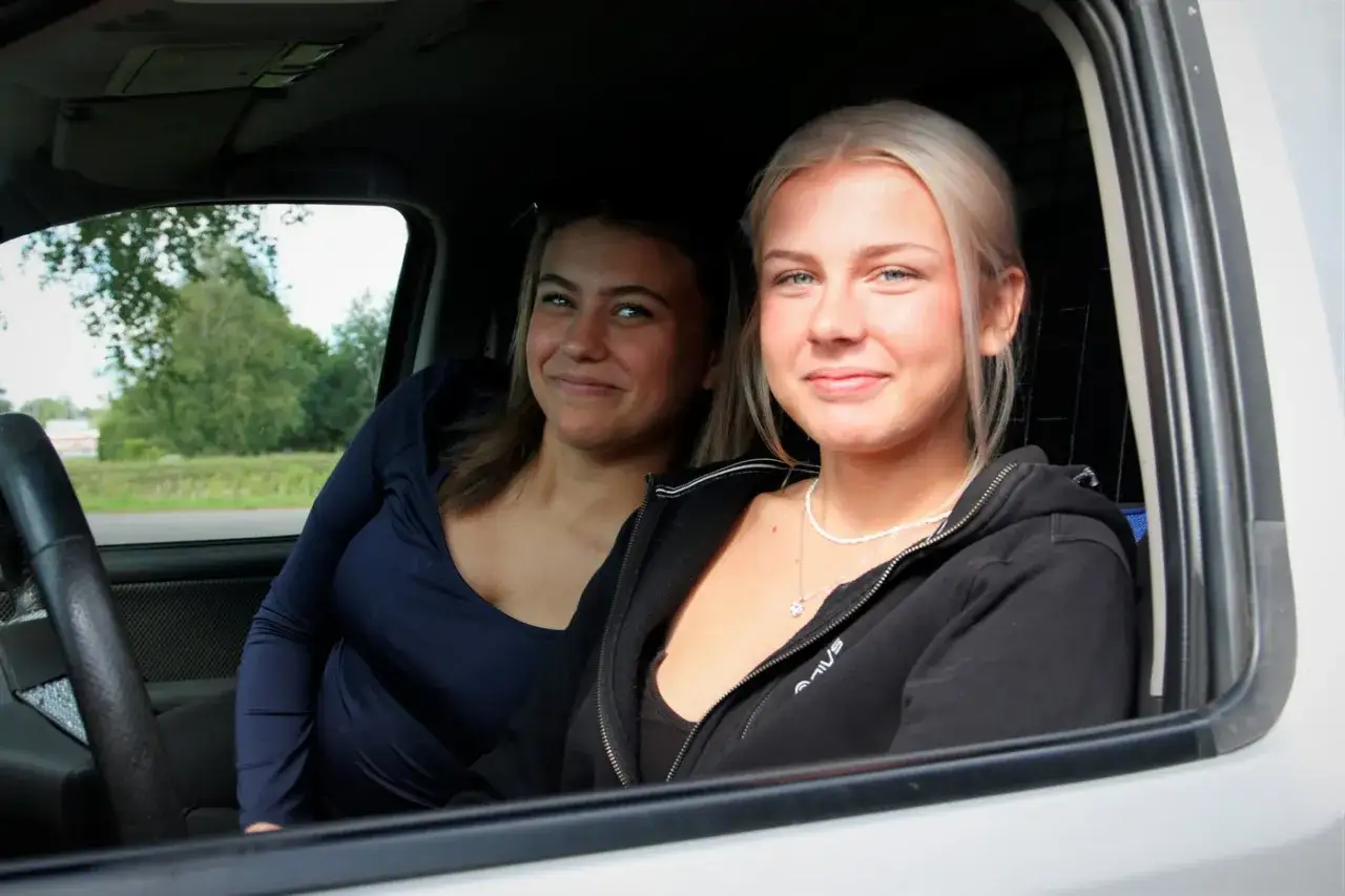 Två glada tjejer sitter i en EPA. Frågan