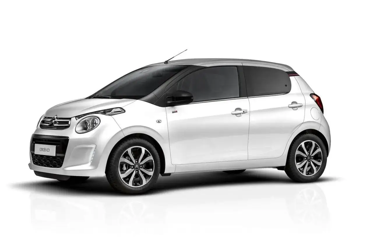 Biały Citroen C1 z czarnym dachem i przyciemnianymi szybami, prezentujący się na białym tle.