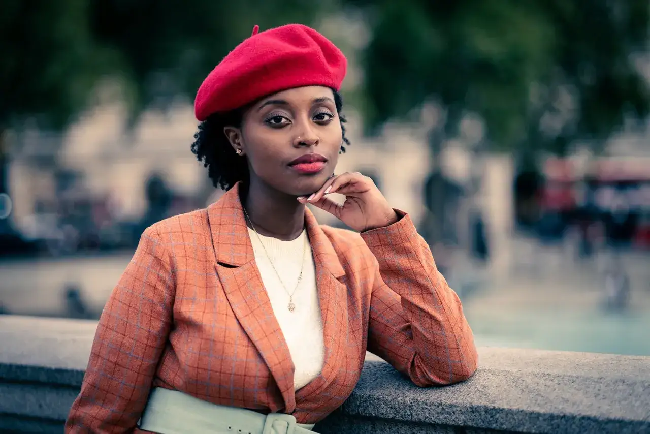Donna con berretto rosso e tailleur a quadri, un'ispirazione per un reportage fotografico di moda urbana.