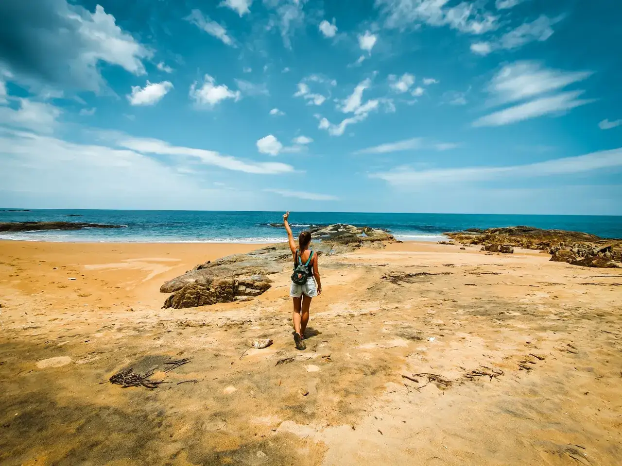 Frau mit Rucksack am Strand, genie&szlig;t die Sonne. Perfekte Bedingungen f&uuml;r die **khao lak beste reisezeit**.