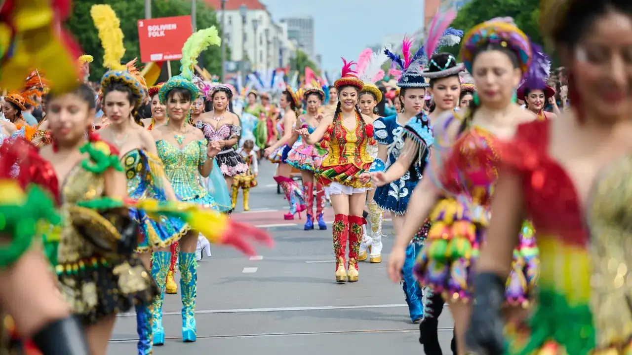 Bunte Trachten und Federschmuck beim **Carnival Berlin**. Bolivianische Folklore zieht durch die Stadt.
