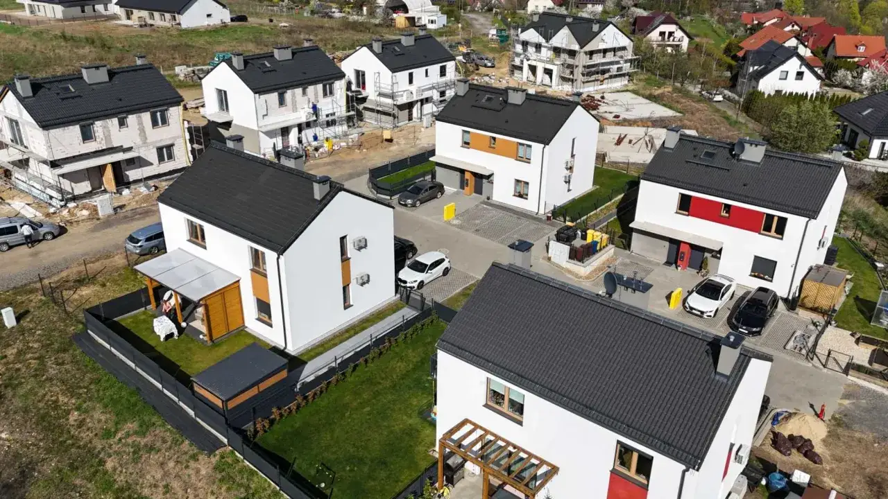 Nowe domy w zabudowie szeregowej, w trakcie budowy i wykończenia, świadczą o dynamicznym wbg development.