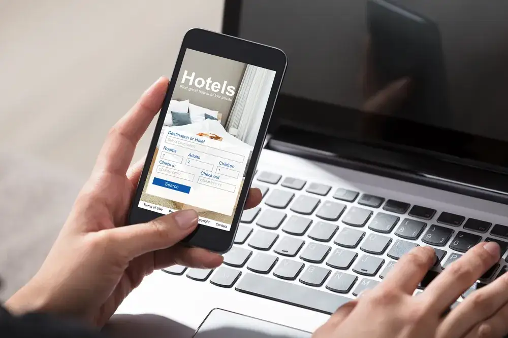 osoba rezerwująca nocleg online na laptopie