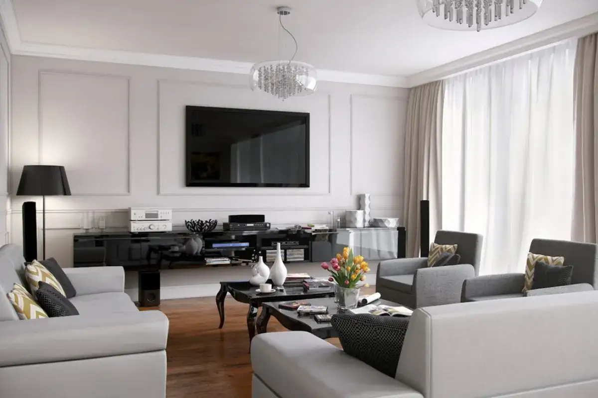 Elegancka ściana ze sztukaterią w salonie, z telewizorem i nowoczesnymi meblami.