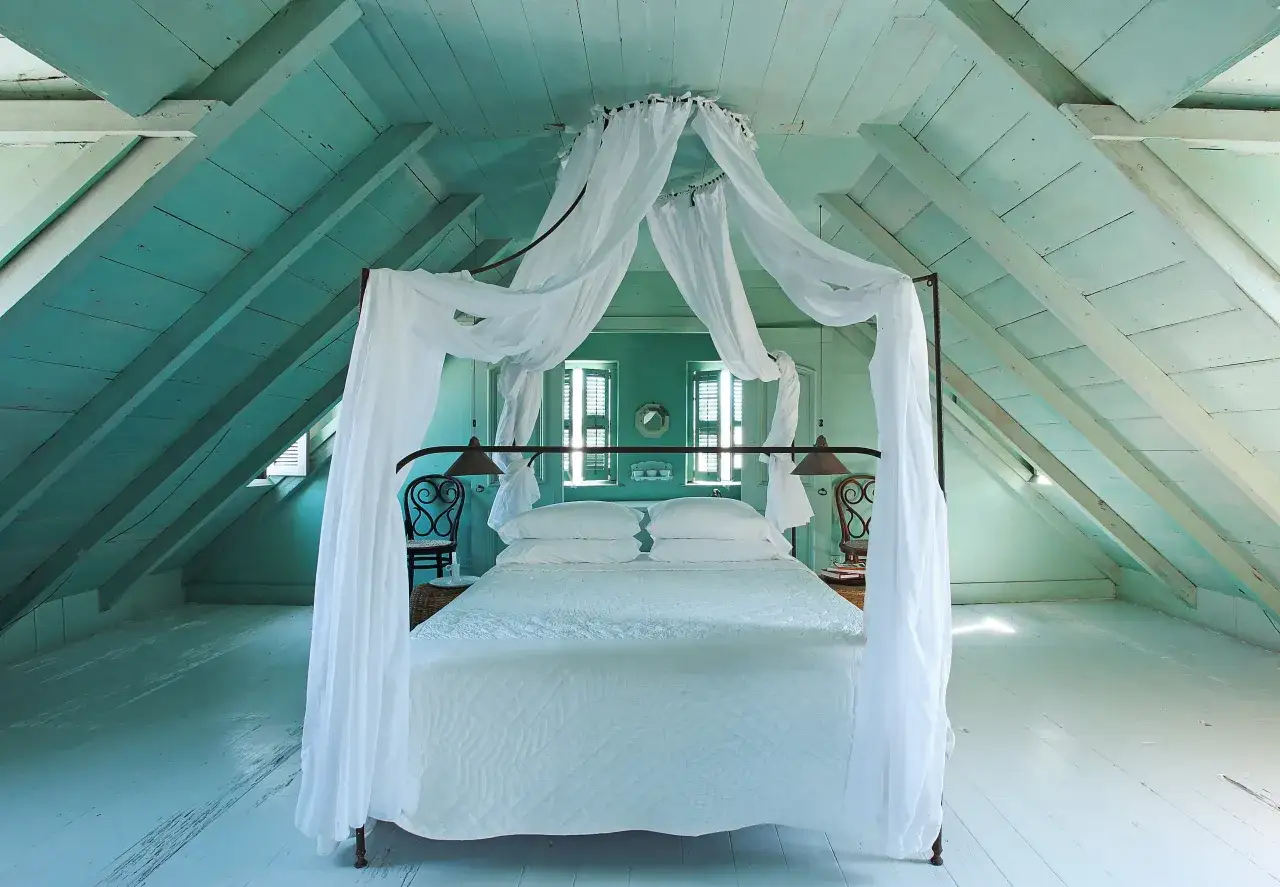 Traumhaftes Himmelbett mit weißen Vorhängen unter einer teal-farbenen Dachschräge. Tolle Himmelbett Vorhang Ideen für ein maritimes Schlafzimmer.