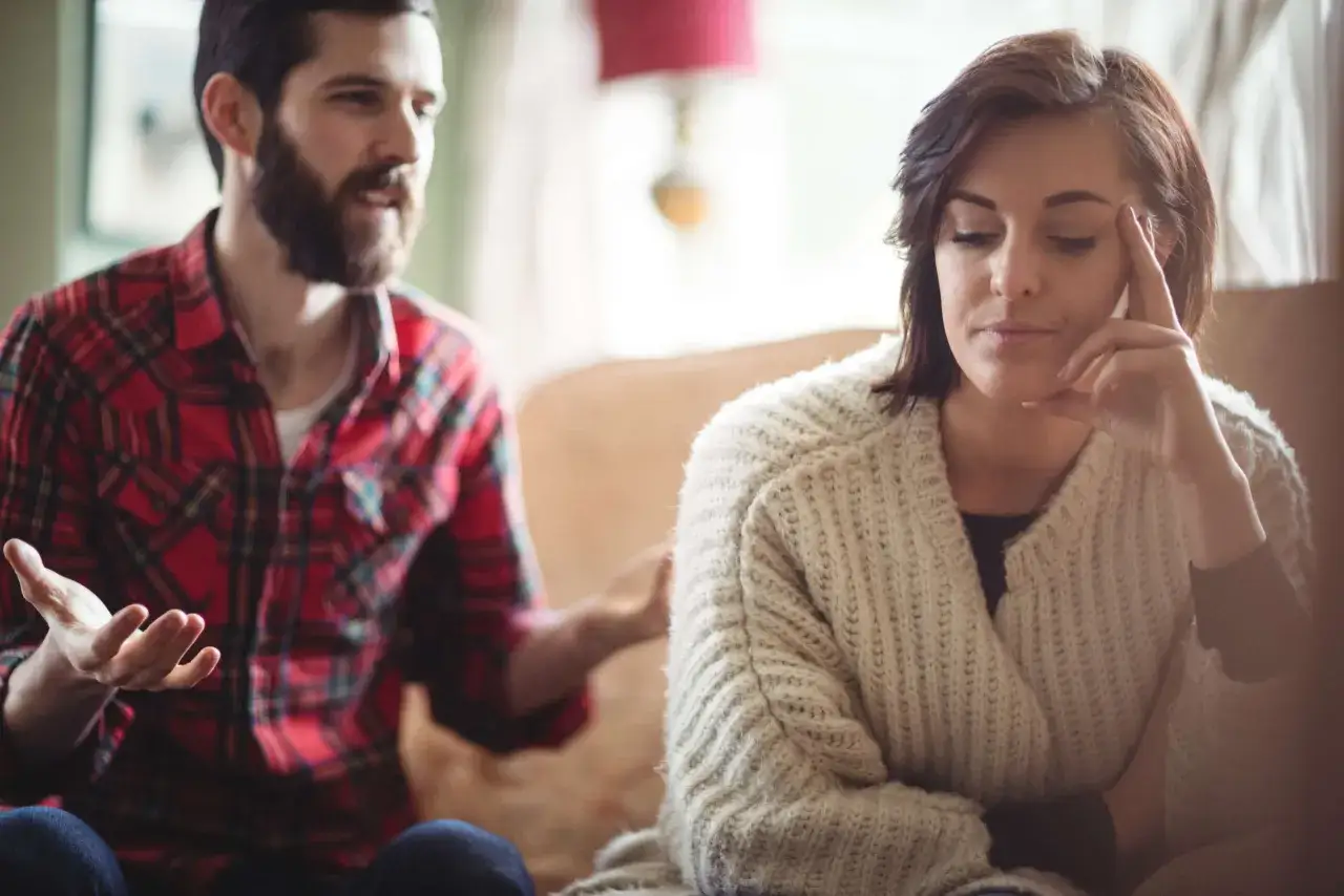 Hombre con barba en camisa a cuadros habla con mujer pensativa, &iquest;es amor o dependencia?