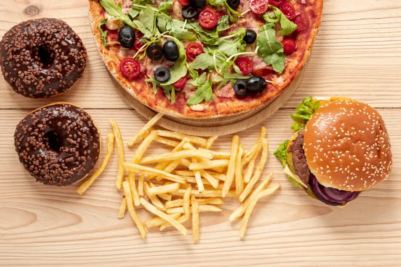 Pizza, frytki, dwa pączki w czekoladzie i burger. Taka uczta to mnóstwo tłuszczów nasyconych, które mogą być niezdrowe.