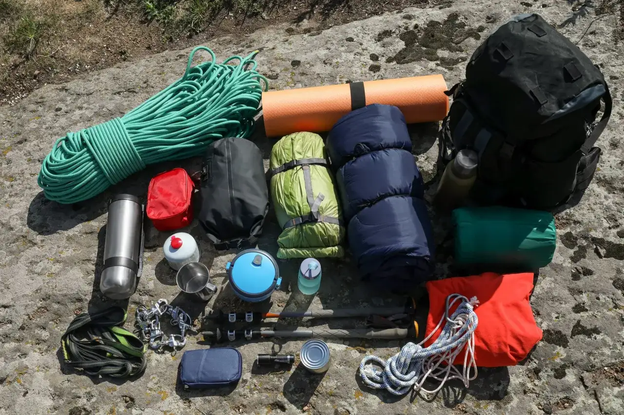 Wszystkie niezbędne gadżety pod namiot: lina, śpiwory, karimata, plecak, termos, kuchenka, menażka, latarka, kijki trekkingowe i inne akcesoria.