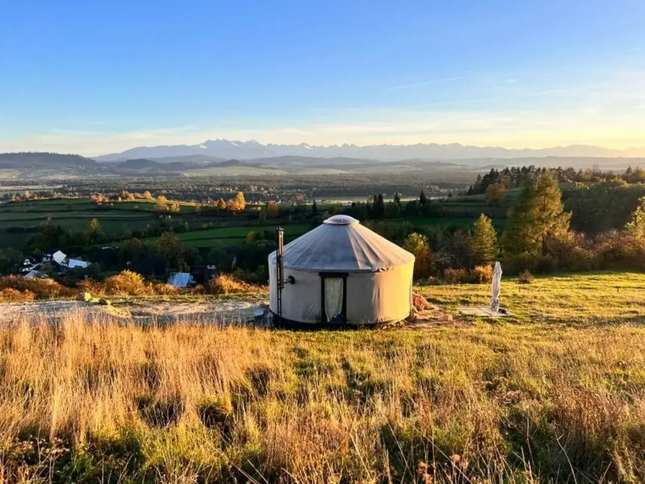 Malowniczy glamping nad jeziorem, gdzie jurta stoi na wzgórzu z widokiem na góry. Idealne miejsce na relaks.