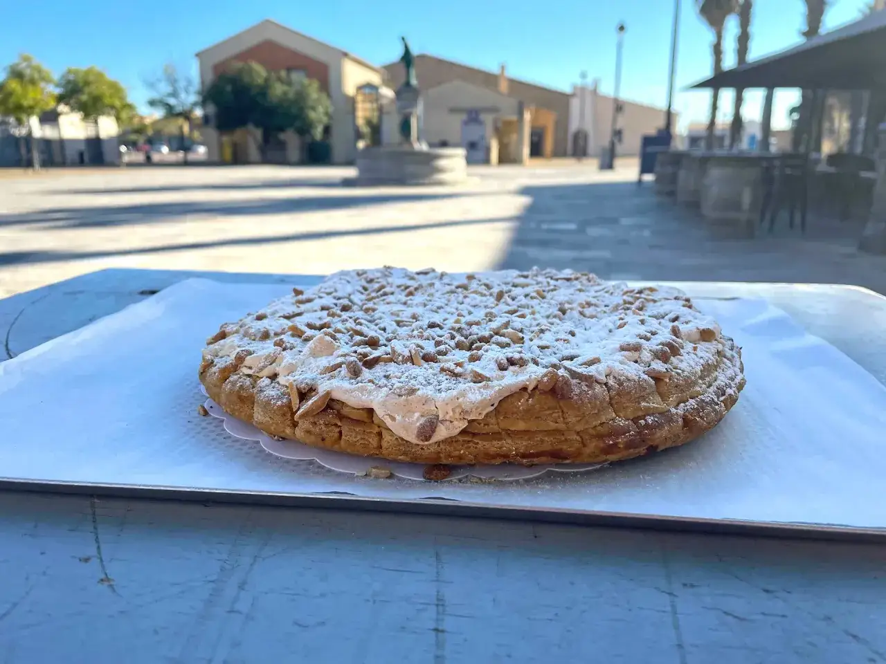 Délicieuse tarte aux pignons de Gruissan, saupoudrée de sucre glace, prête à être dégustée en terrasse.