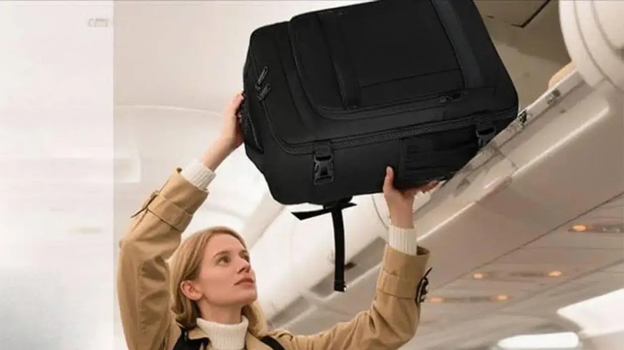 Personne gérant sa réservation easyJet sur un ordinateur portable avec une valise à côté