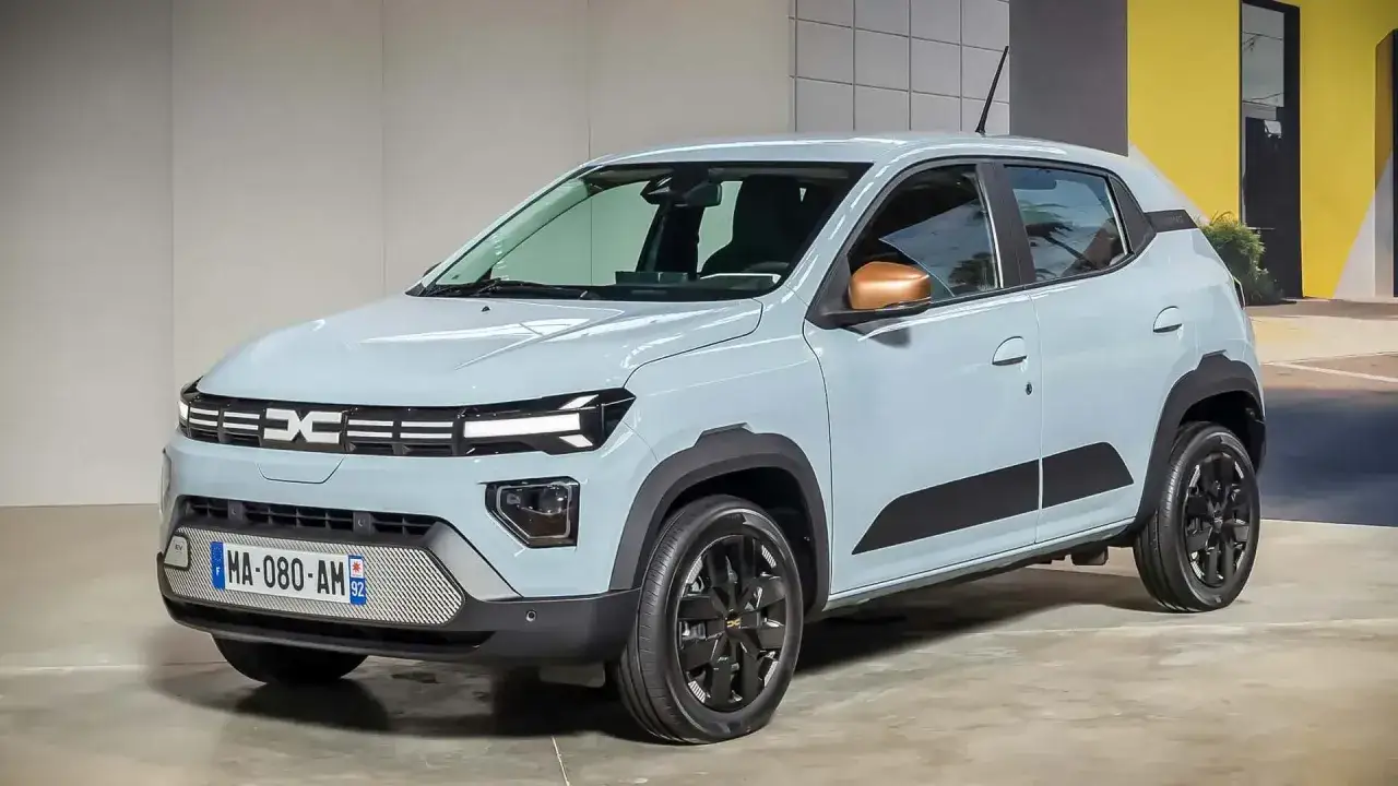 Jasnoniebieski samochód Dacia Spring z czarnymi akcentami i miedzianymi lusterkami. Nowe dacia modele to przyszłość motoryzacji.