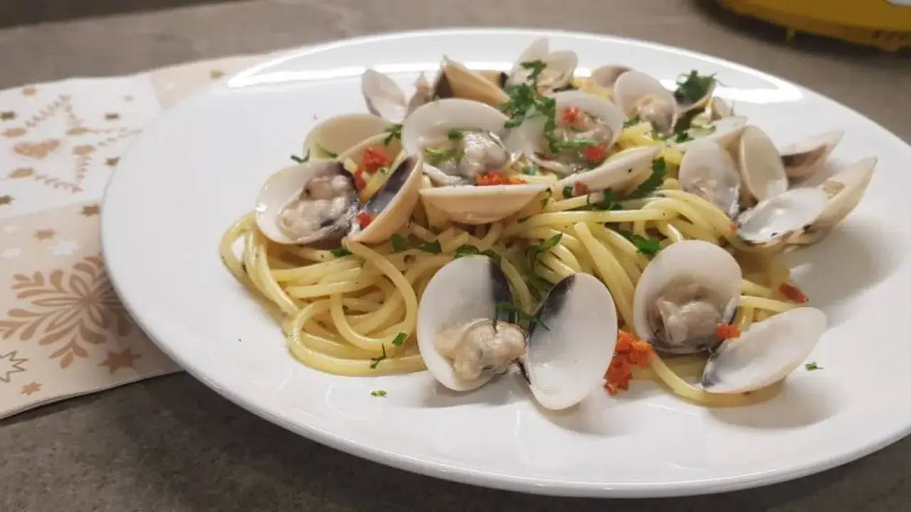 Spaghetti con vongole surgelate, un piatto gustoso e veloce, arricchito da prezzemolo fresco e un tocco di peperoncino.