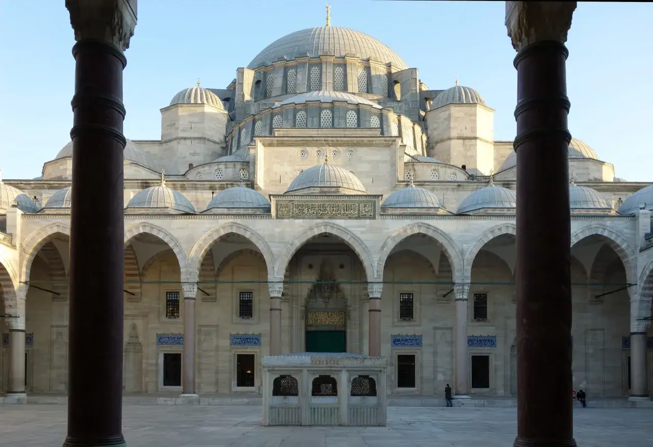 Prachtvolle islamische Architektur einer Moschee mit Kuppeln und Bögen, gesehen durch Säulen.