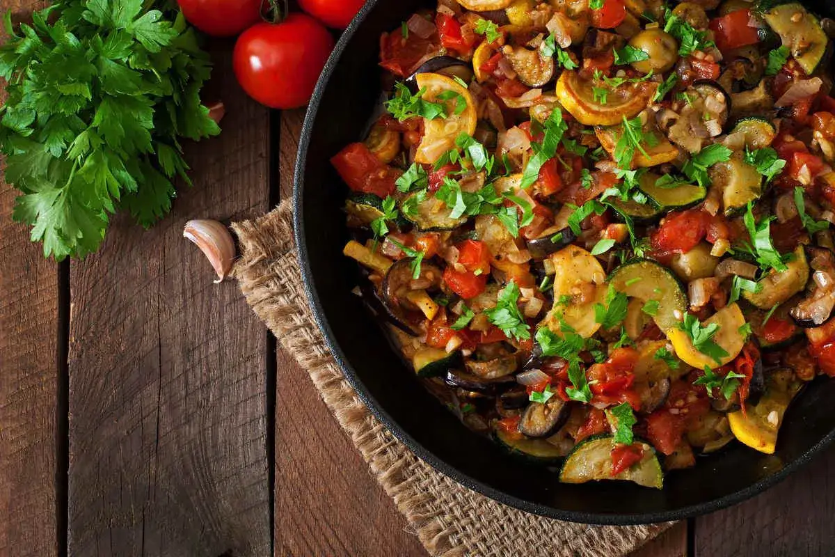 Melanzane e zucchine in padella, un contorno colorato e saporito, pronto per essere gustato.