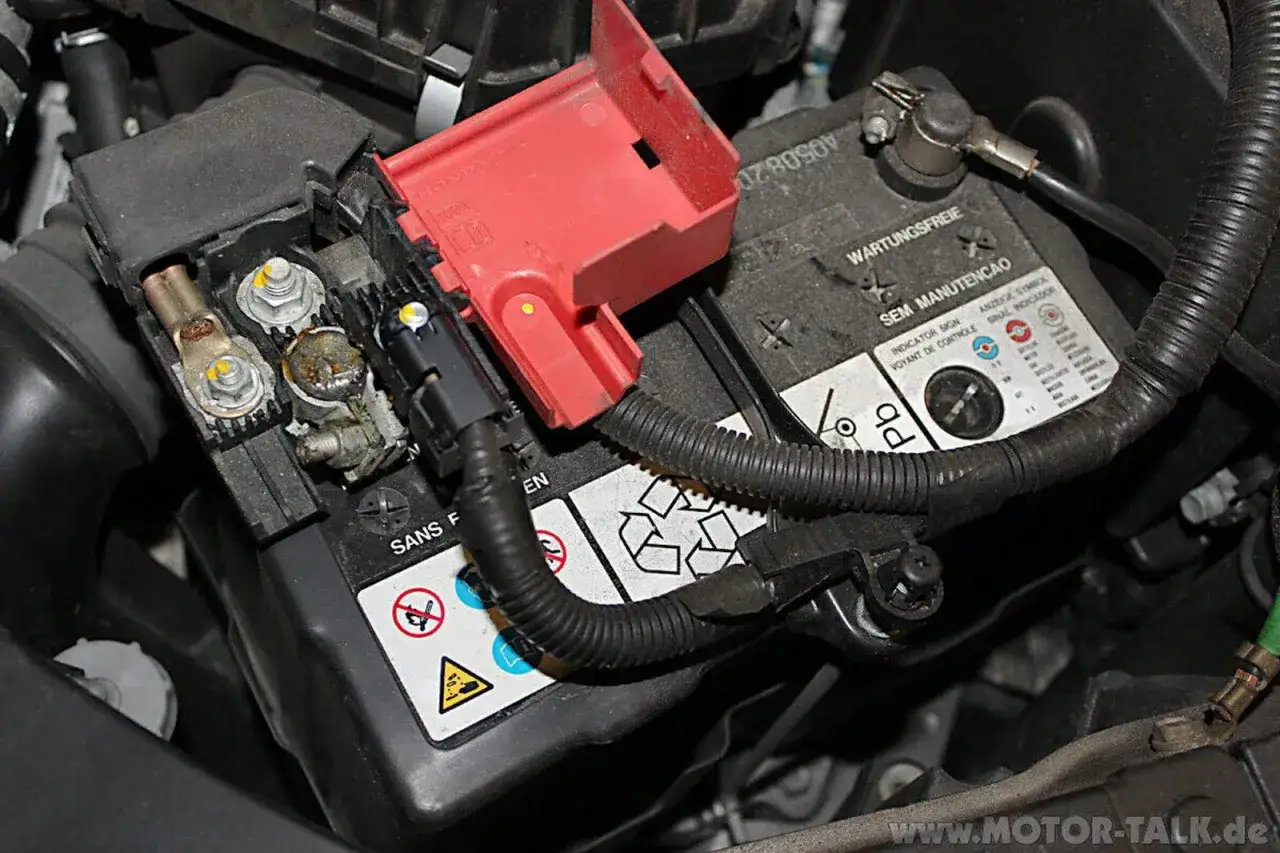 Batteriepole eines Honda Jazz, bereit für den Wechsel. Die rote Abdeckung schützt die Anschlüsse.