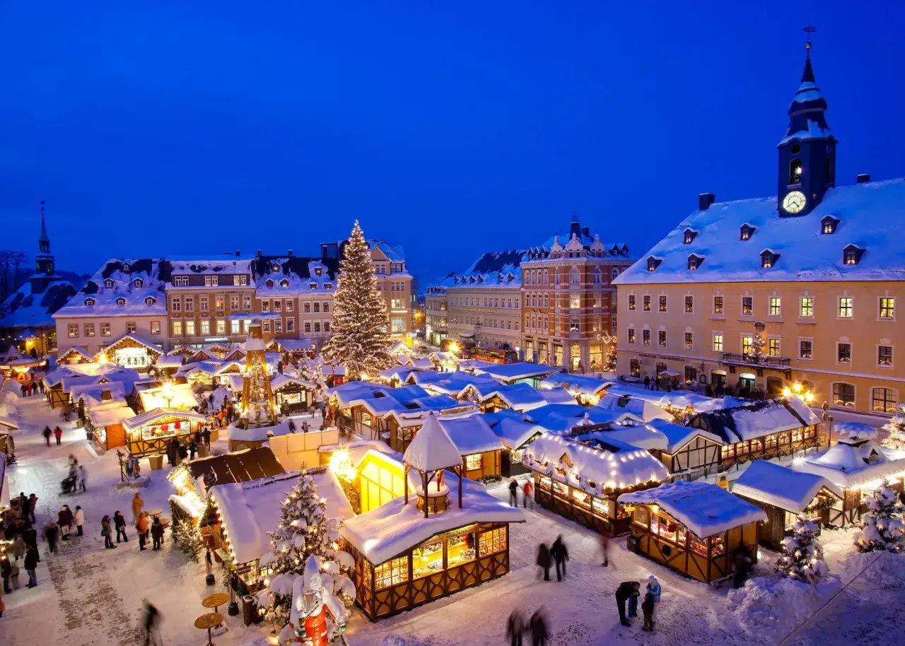 Magiczny jarmark bożonarodzeniowy w Niemczech. Śnieg, światła, choinka i ludzie tworzą świąteczną atmosferę.