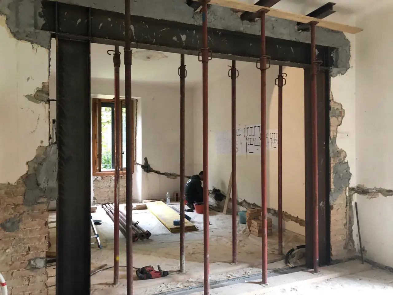 Creazione di una nicchia nel muro portante con rinforzi in acciaio e puntelli. Lavori in corso.