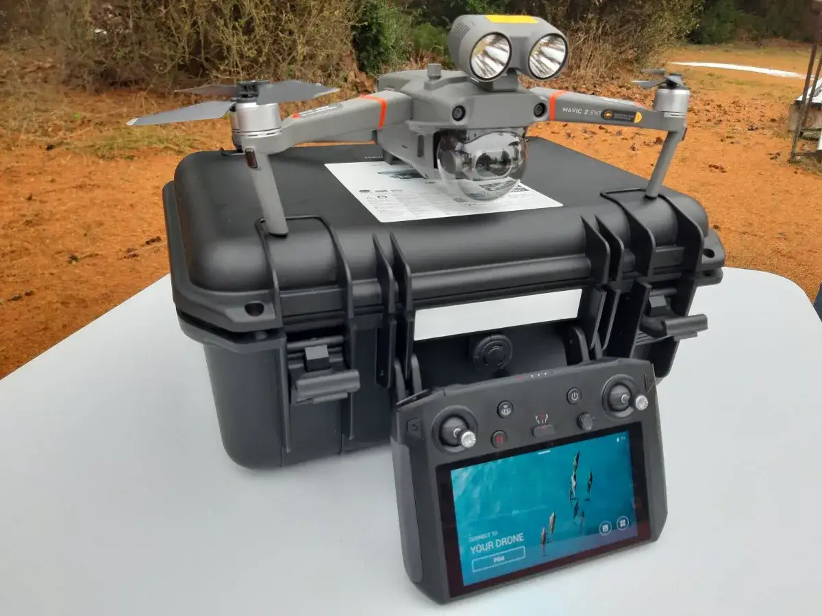 Dron policyjny Mavic 2 Enterprise z pilotem i walizką. Gotowy do akcji, by zapewnić bezpieczeństwo.