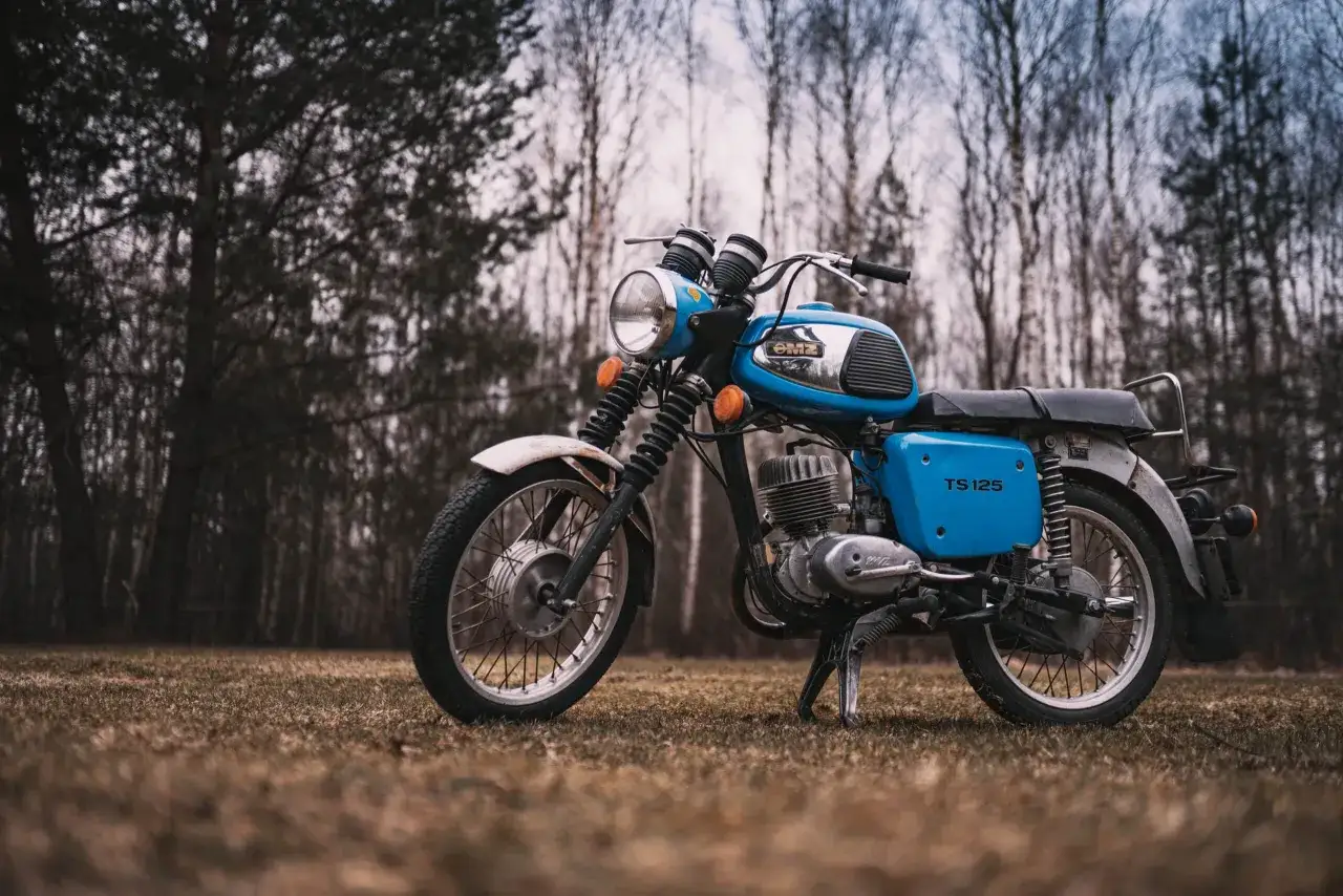Niebieski motocykl MZ TS 125 na tle lasu. Poznaj dane techniczne tego klasyka.